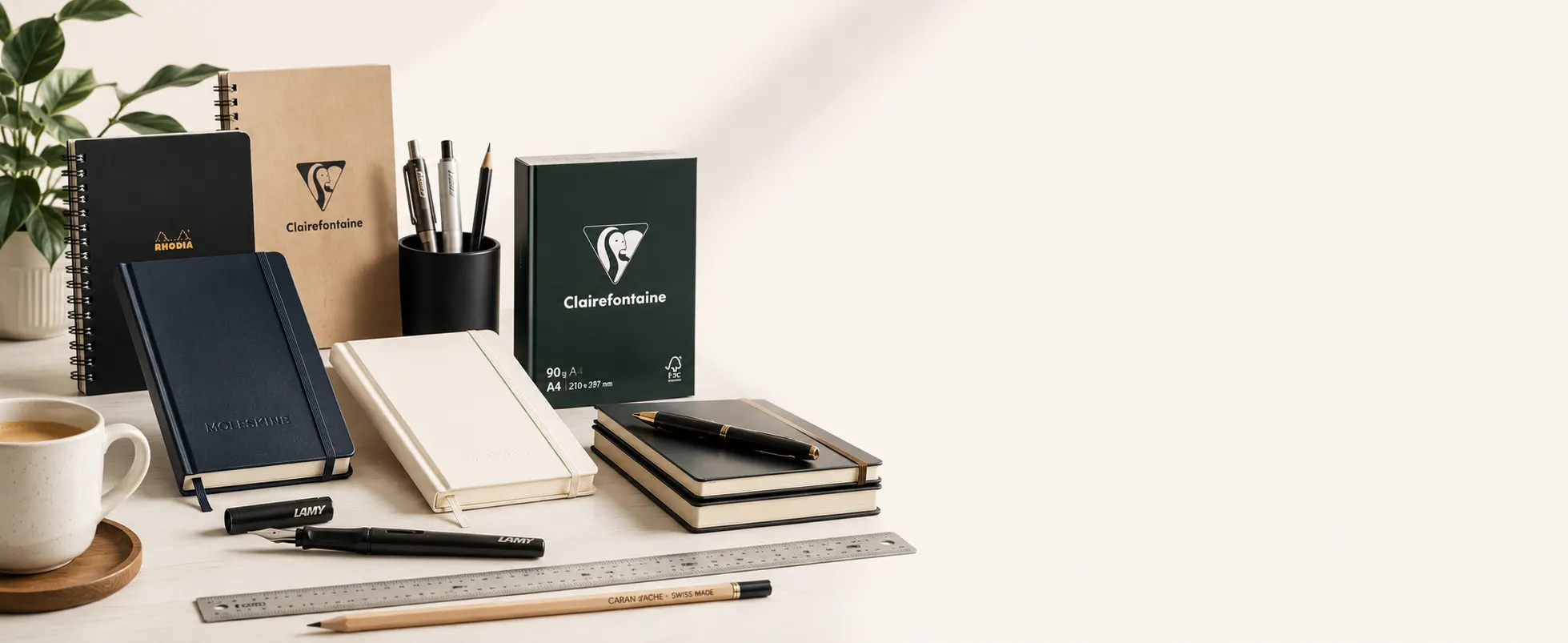 Sélection élégante de carnets, stylos et fournitures de papeterie présentée dans un décor lumineux.